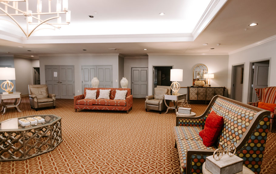 Spacious common room with comfortable couches and chairs for residents